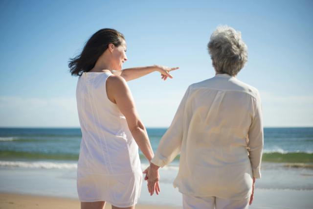adult child and elderly mom on beach