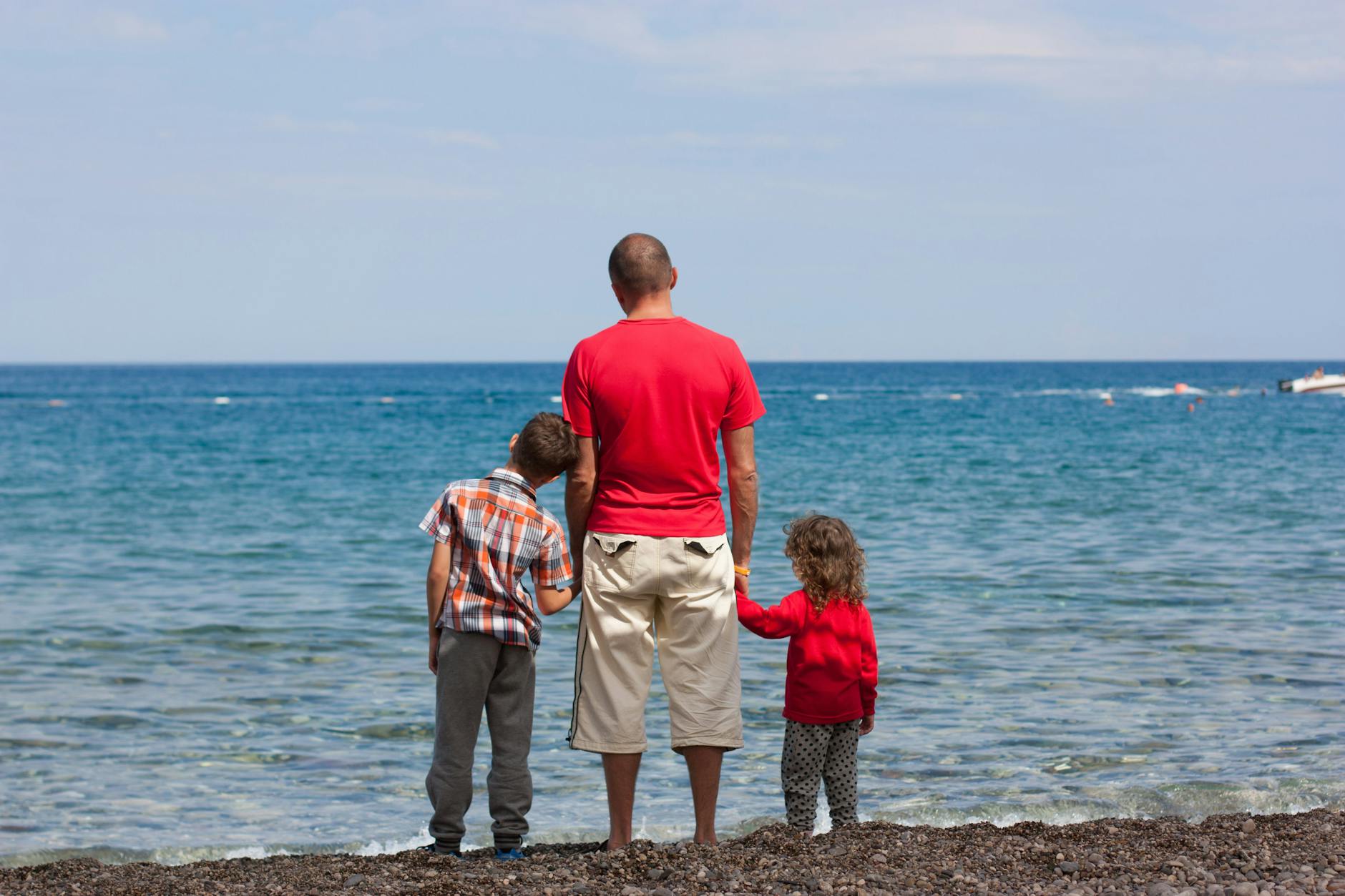 dad on beach with two kids